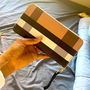 A beige, black, white and grey stripe hand purse.